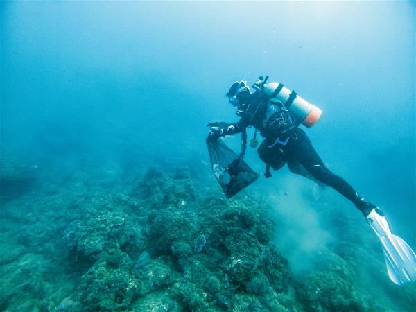要清除落在珊瑚礁群上的海廢，需要帶著網袋潛入海中用手撿拾，大型海廢則綁上記號，由船隻另外來拉運。